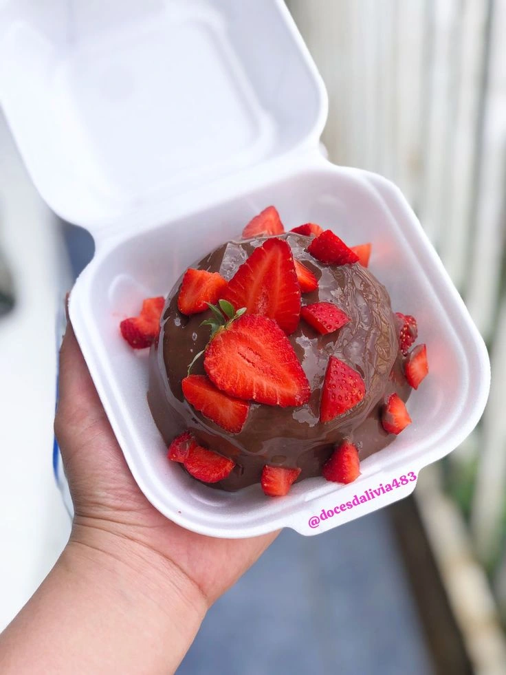 Mini bolo com cobertura de chocolate e pedaços de morango em embalagem individual